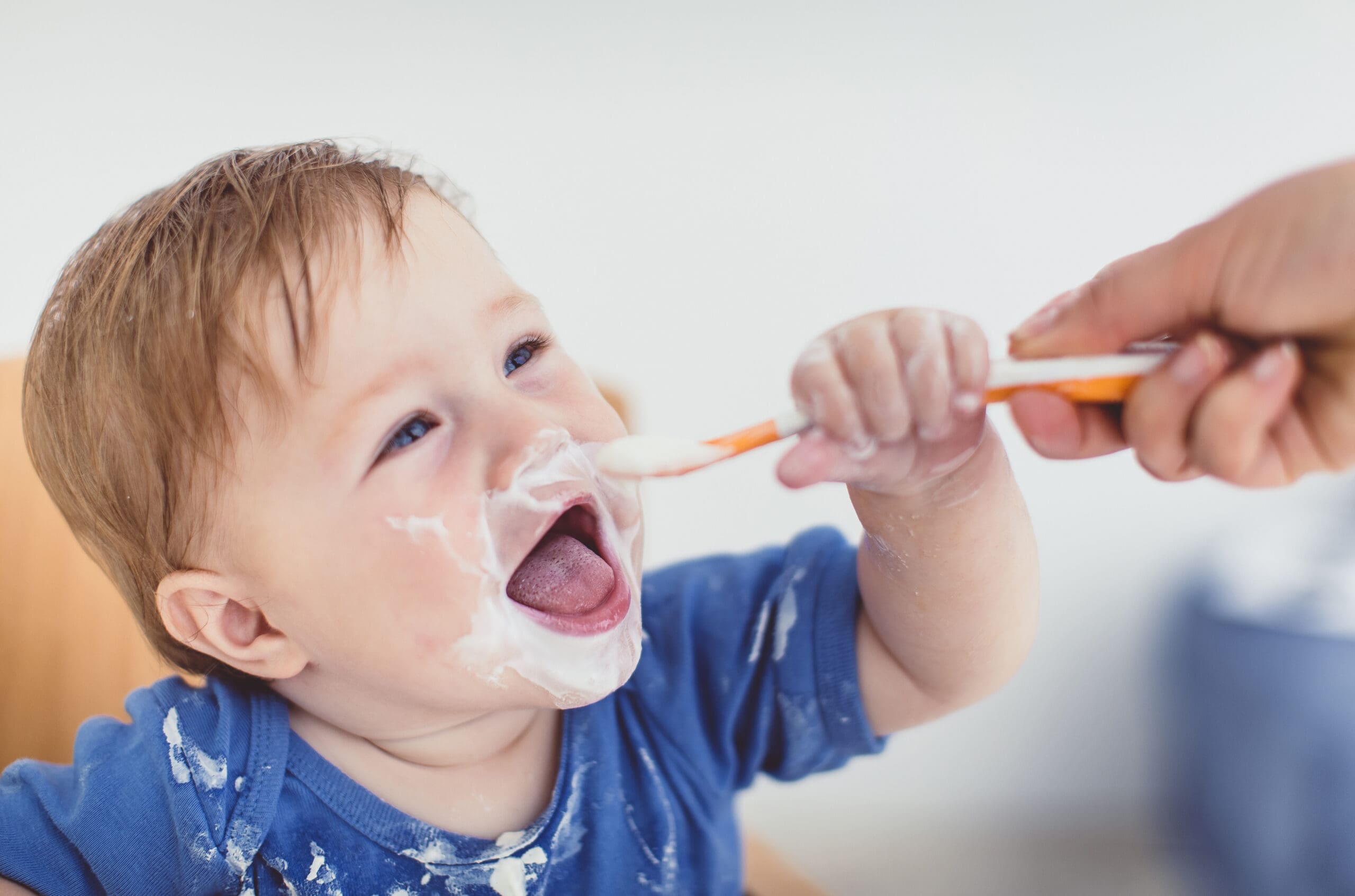 parent-feeding-toddler-with-a-spoon